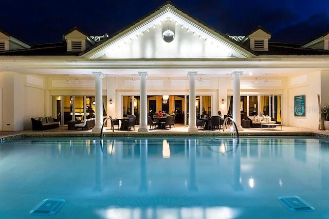 pool at twilight featuring a patio area