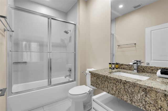 full bathroom with toilet, bath / shower combo with glass door, vanity, and tile patterned floors