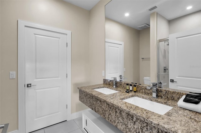 bathroom with toilet, a shower with shower door, vanity, and tile patterned flooring