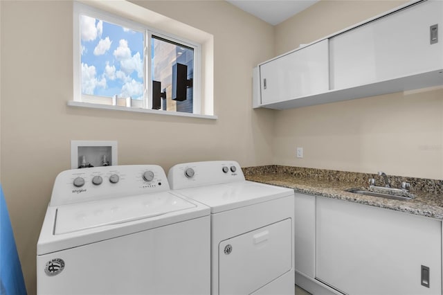 washroom featuring cabinets, sink, and washing machine and dryer