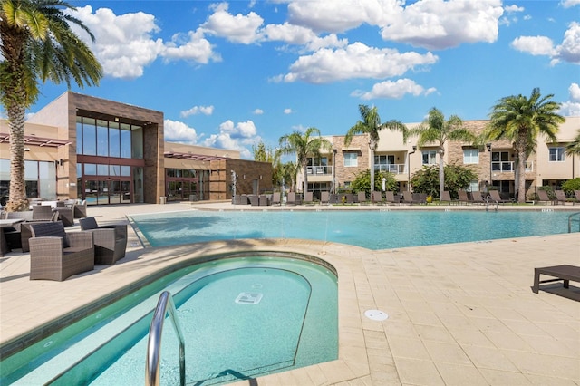 view of swimming pool featuring a community hot tub and a patio