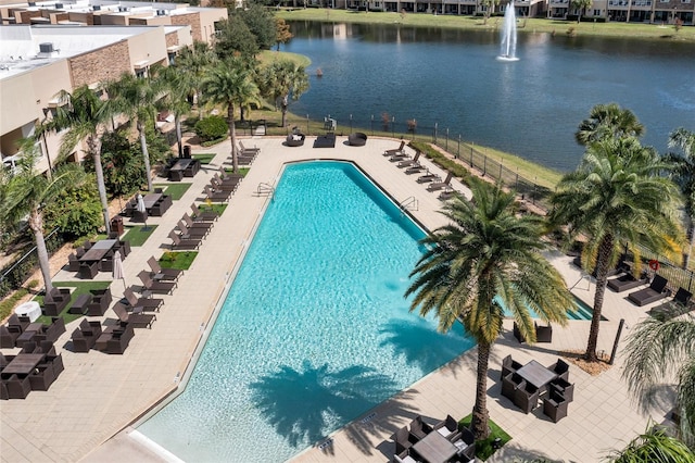 view of swimming pool featuring a patio and a water view