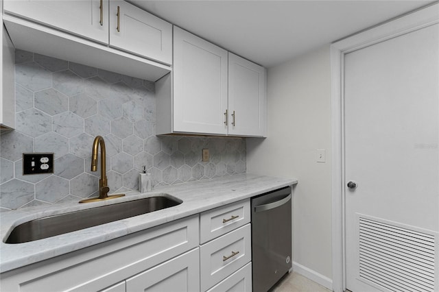 kitchen with white cabinets, sink, stainless steel dishwasher, decorative backsplash, and light stone counters