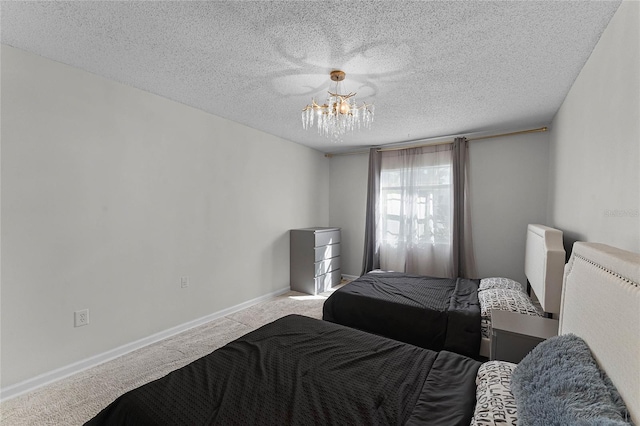 bedroom with light carpet, a textured ceiling, and an inviting chandelier