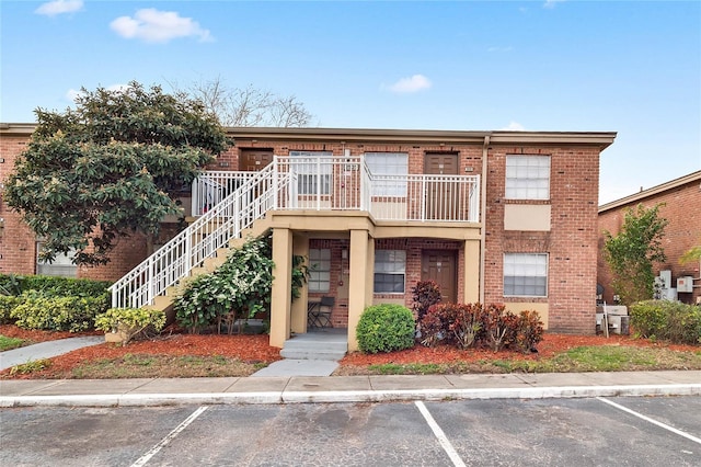 view of property featuring uncovered parking and stairway