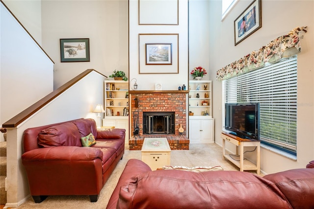 carpeted living room with a high ceiling and a brick fireplace