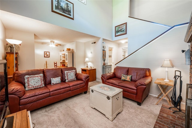 living room with a high ceiling, ceiling fan, and light colored carpet