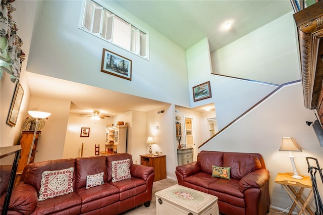 living room with carpet flooring, ceiling fan, and a high ceiling