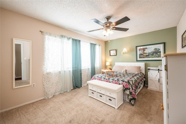 carpeted bedroom with ceiling fan and a textured ceiling