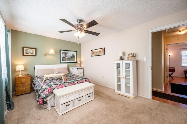 carpeted bedroom featuring a textured ceiling and ceiling fan