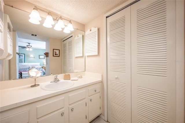 bathroom featuring vanity, a textured ceiling, and ceiling fan