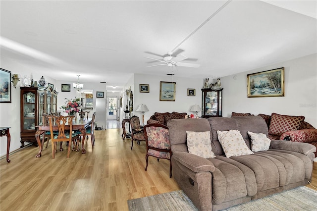 living room featuring light hardwood / wood-style floors and ceiling fan with notable chandelier