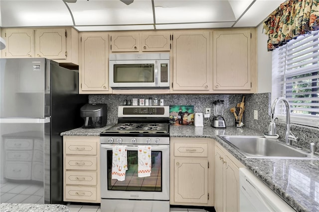 kitchen featuring sink, appliances with stainless steel finishes, decorative backsplash, and light tile patterned floors