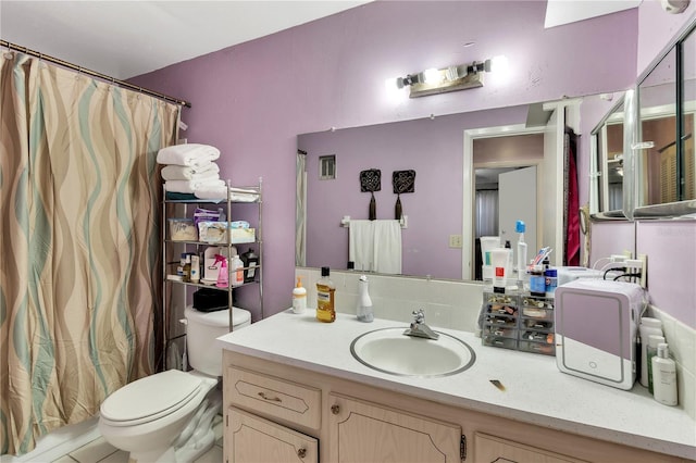 bathroom with vanity, a shower with shower curtain, and toilet