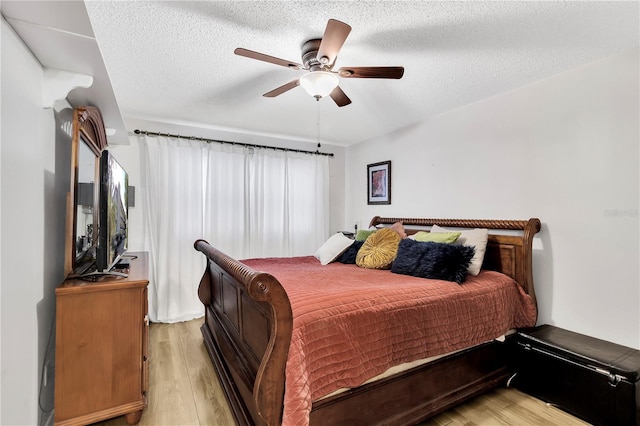 bedroom featuring a textured ceiling, light hardwood / wood-style floors, and ceiling fan