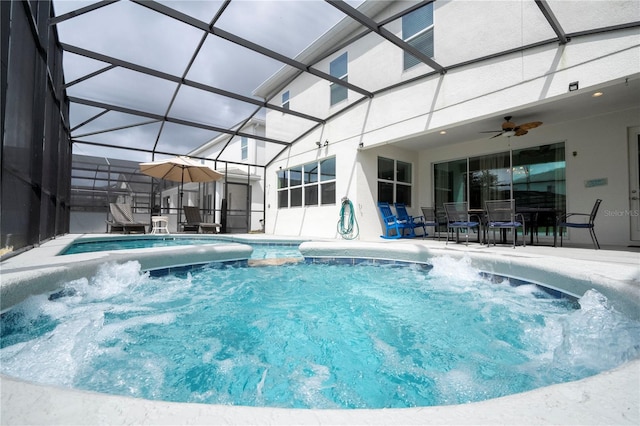 view of swimming pool with a jacuzzi, ceiling fan, a patio area, and a lanai