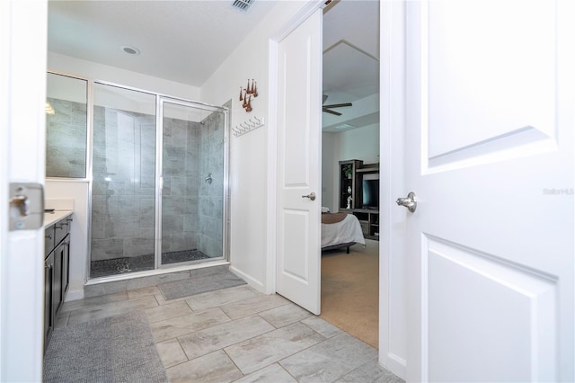 bathroom featuring vanity, ceiling fan, and walk in shower