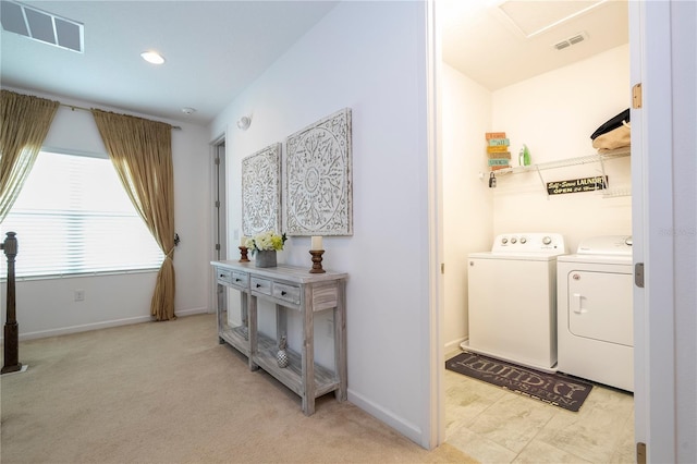 laundry area with washer and dryer and light colored carpet