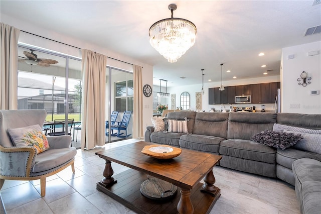 living room with ceiling fan with notable chandelier