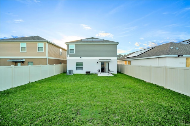 back of house featuring central AC, a yard, and a patio area