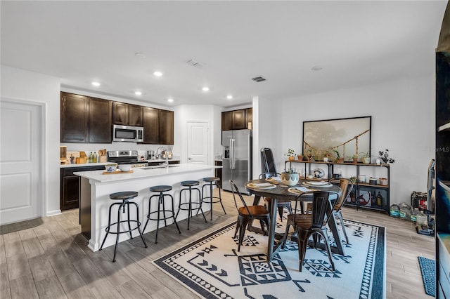 dining area with sink and light hardwood / wood-style floors