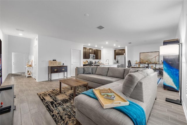 living room with sink and light hardwood / wood-style flooring