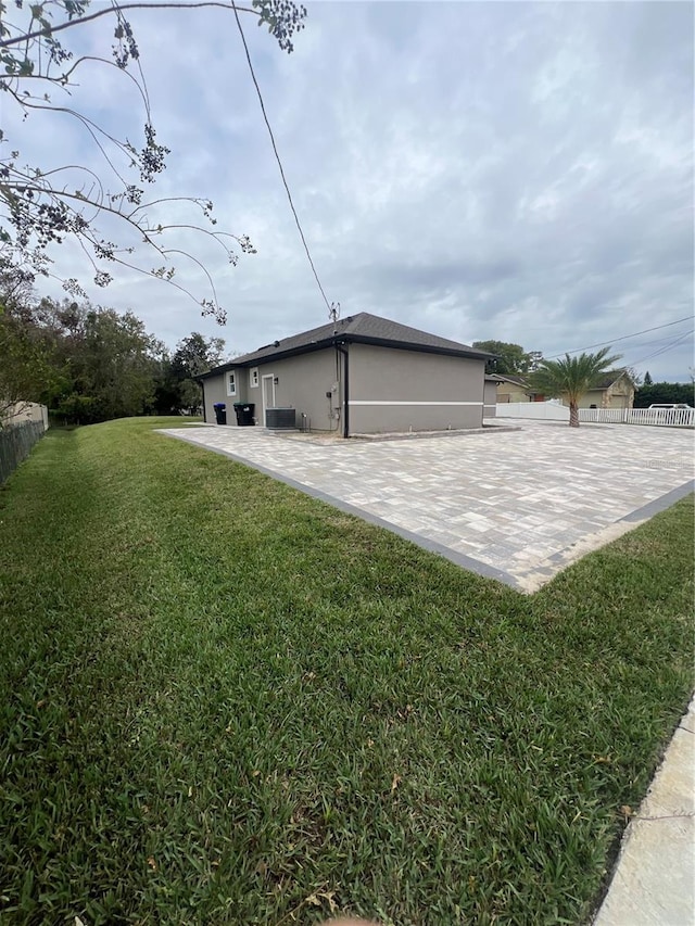 view of property exterior with a patio area and a yard