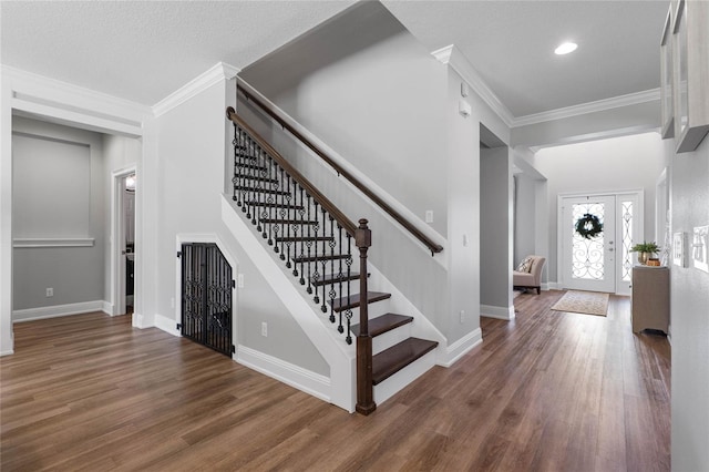 entryway with dark wood-style flooring, crown molding, and baseboards