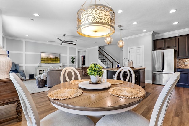 dining room with recessed lighting, dark wood-type flooring, visible vents, stairs, and crown molding