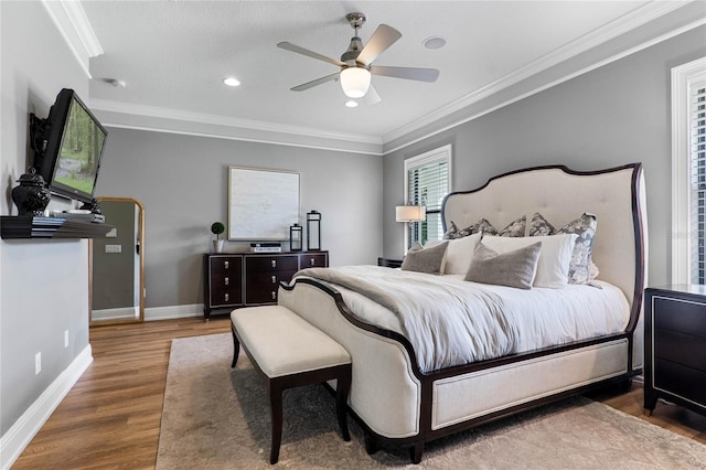 bedroom with ceiling fan, baseboards, crown molding, and wood finished floors