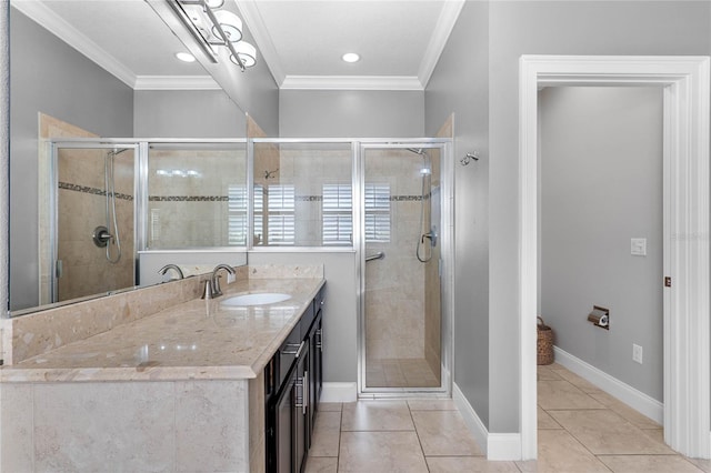 bathroom featuring crown molding, a stall shower, vanity, baseboards, and tile patterned floors