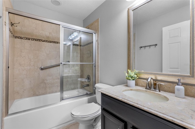 bathroom with toilet, enclosed tub / shower combo, and vanity