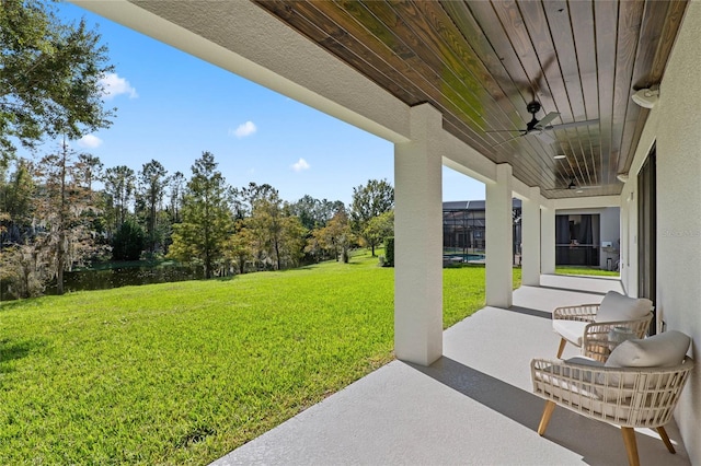 view of yard featuring ceiling fan, a patio area, and a lanai