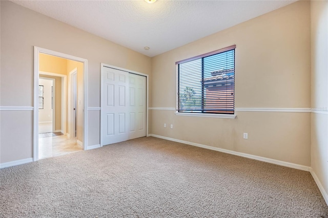 unfurnished bedroom featuring a closet, carpet flooring, and a textured ceiling