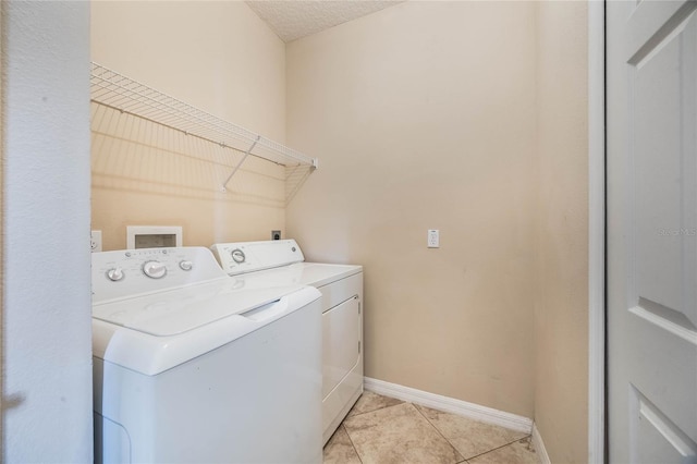 laundry room featuring light tile patterned flooring and washer and clothes dryer