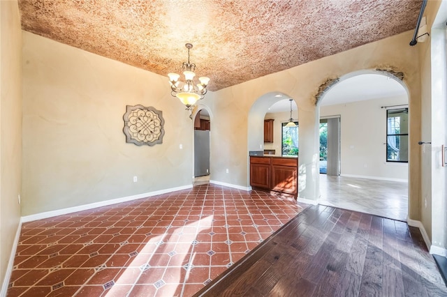 unfurnished room with dark hardwood / wood-style floors and an inviting chandelier