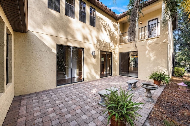 rear view of house with a balcony and a patio