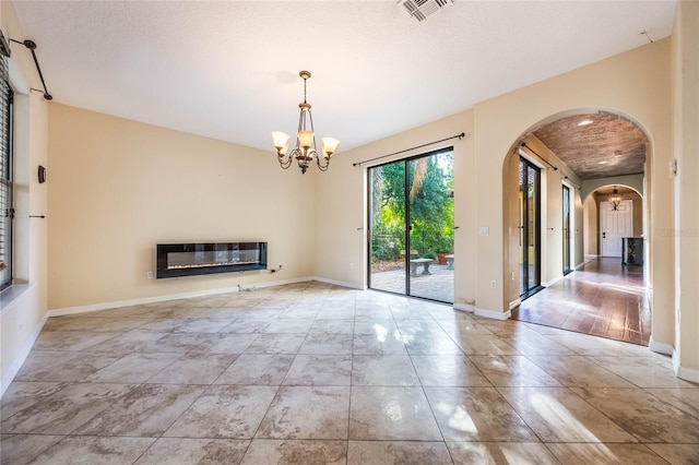 interior space with light hardwood / wood-style flooring, a textured ceiling, a chandelier, and heating unit