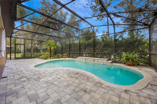 view of pool featuring pool water feature, a patio, and glass enclosure