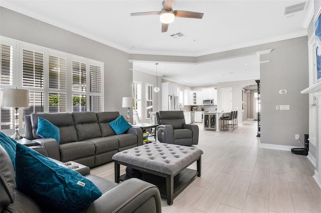 living room with ceiling fan, ornamental molding, and light hardwood / wood-style flooring