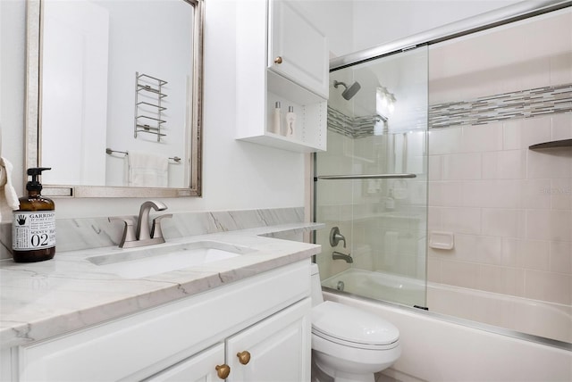 full bathroom featuring vanity, bath / shower combo with glass door, and toilet