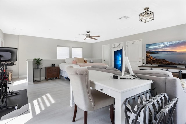 dining space with light hardwood / wood-style floors and ceiling fan