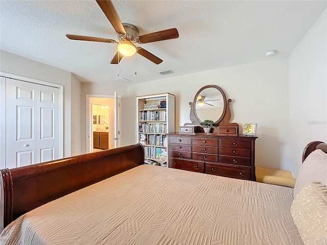 bedroom with a closet, ceiling fan, connected bathroom, and a textured ceiling