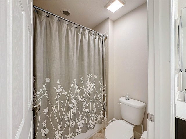 bathroom featuring toilet and tile patterned flooring