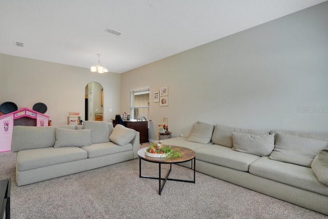 carpeted living room with a chandelier