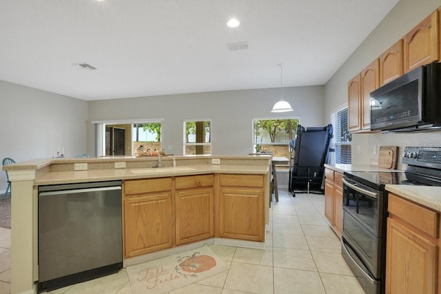 kitchen featuring decorative light fixtures, a center island with sink, stainless steel appliances, and sink