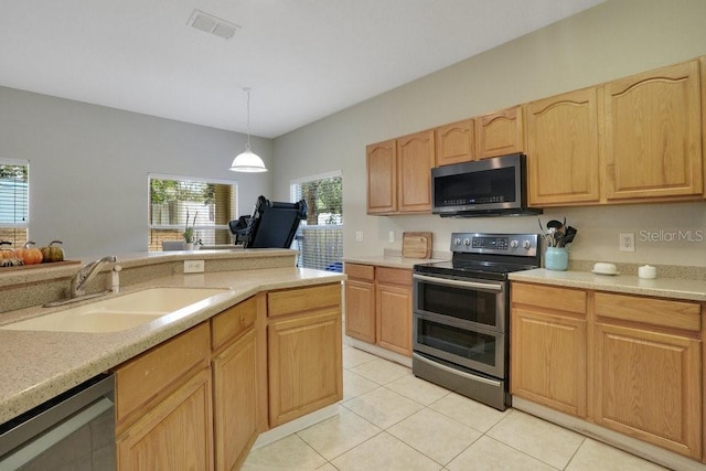 kitchen with decorative light fixtures, stainless steel appliances, sink, and a wealth of natural light