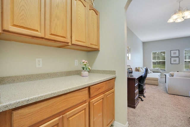 kitchen featuring light brown cabinets, a notable chandelier, and light colored carpet