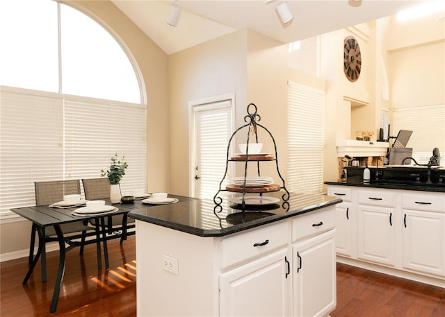 kitchen with sink, a kitchen island, dark hardwood / wood-style flooring, white cabinetry, and lofted ceiling