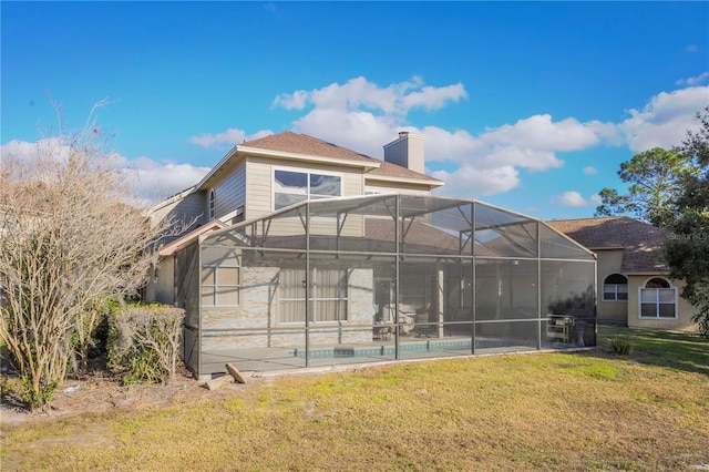 back of house with a lanai, a yard, and a patio area